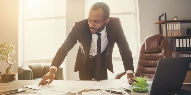 Male attorney reviewing documents at a desk deciding whether to grow law firm