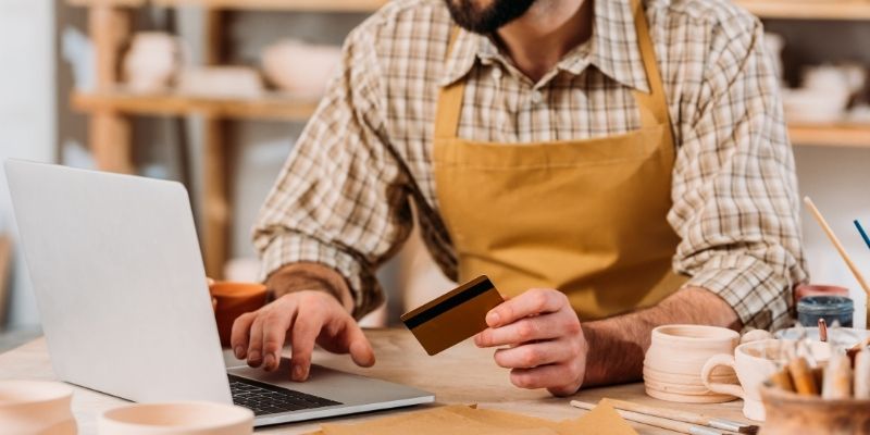 male business owner making a purchase on his laptop using a business credit card