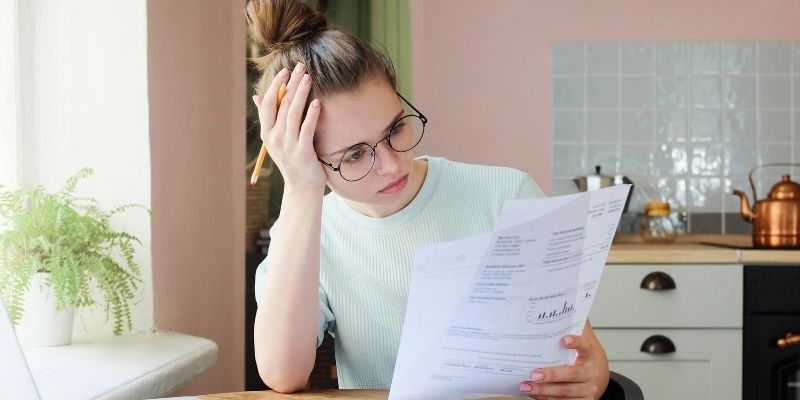 female business owner looking confused while reading small business loan paperwork