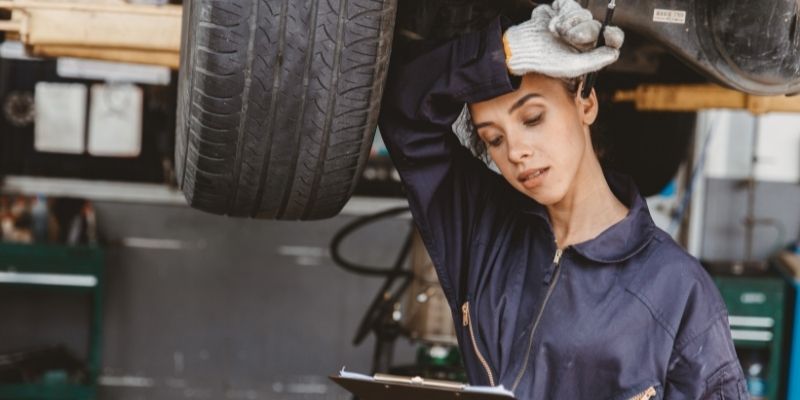 female mechanic small business owner reading tablet