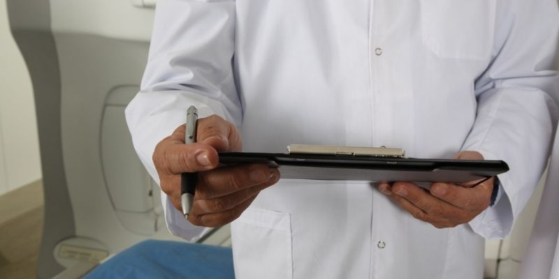 male physician holding patient notes