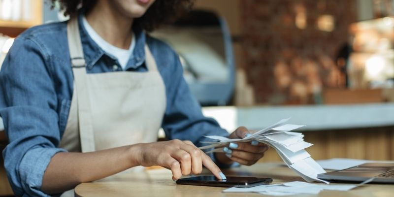 female business owner calculating receipt totals