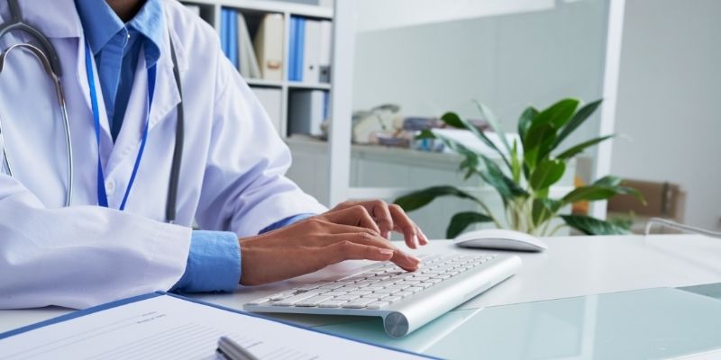 male doctor researching medical practice loan options on computer