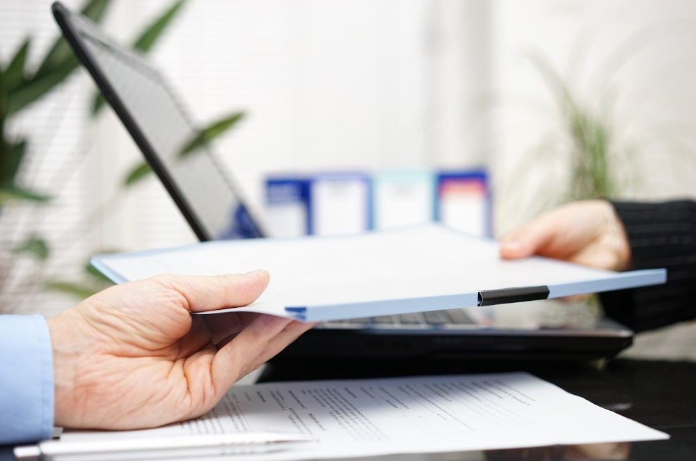 Why It’s Important to Compare Small Business Loan Offers: Businessman and businesswoman are exchanging business loan offer